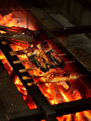 Yakitori spiesjes boven gloeiende binchotan houtskool