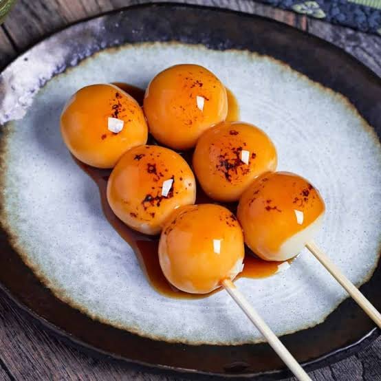 Mitarashi dango aan een spiesje, met glanzende sojasaus