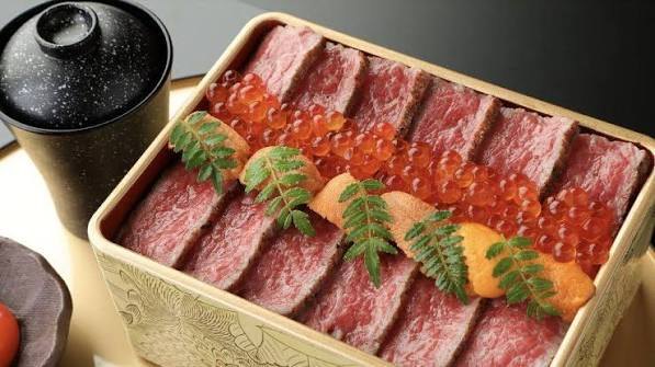 Plakken wagyu in een gouden doos, met zalmeitjes en zeeegel erbovenop