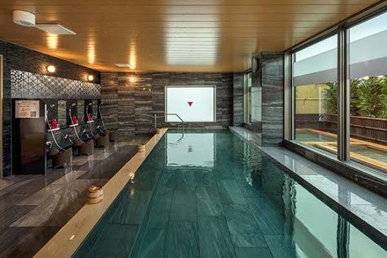 Het grote binnenbad van het hotel, met groene steen en de wasplaatsen langs de zijkant