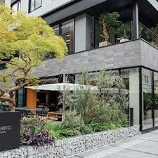 De ingang van het Nohga hotel in Ueno, met het terras en de bomen ervoor