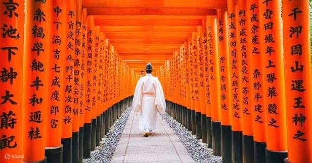 De tempel Kiyomizudera boven de helling, tussen de rode esdoorns bij zonsondergang